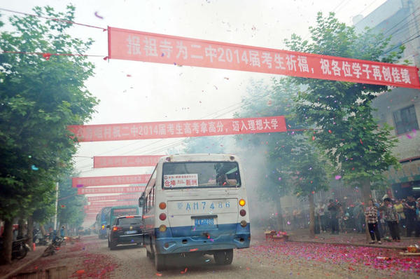 運送考生的車輛依次駛出校門，路邊鞭炮點燃，鑼鼓喧天。