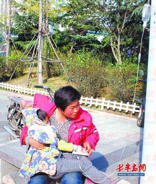 環衛工人劉彩娜陪女兒在路邊打吊瓶