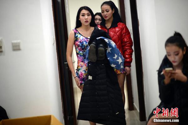 　一位遲到的舉牌女郎剛從化妝間廁所換裝出來。中新社發 稻草 攝 圖片來源：CNSPHOTO