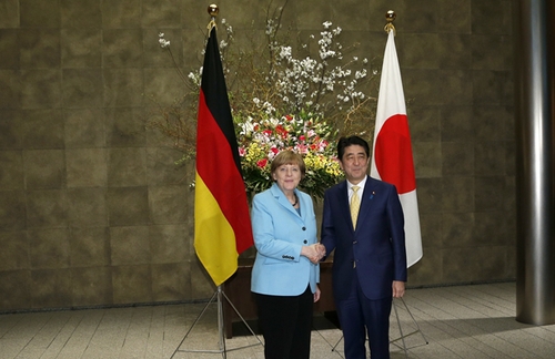 3月9日，在日本東京首相官邸，日本首相安倍晉三（右）歡迎到訪的德國總理默克爾。新華社發