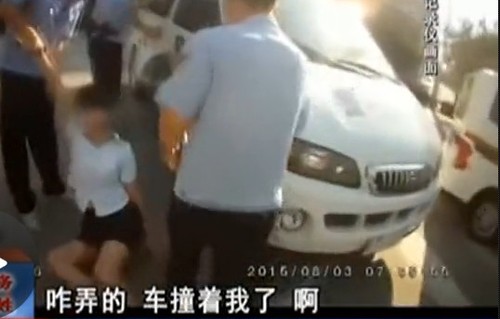 在拉扯中，女子撞到警車(chē)上。