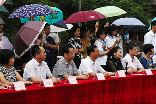 在主席臺上觀看的校領導也堅持不打傘陪學生一起淋雨，身旁站滿了打傘觀看的家長。