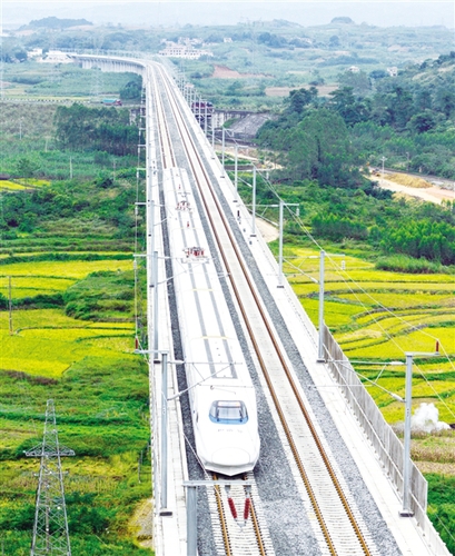 　12月3日，一輛試運行的“和諧號”列車從廣西南寧市隆安縣境內的一座高架橋經過。韋萬忠攝（新華社發）