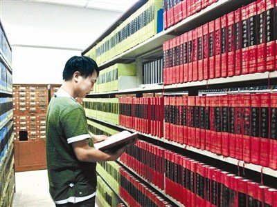 資料圖：一名古籍愛好者正在北大古籍閱覽室翻看“四庫全書”。圖片來源：北京青年報