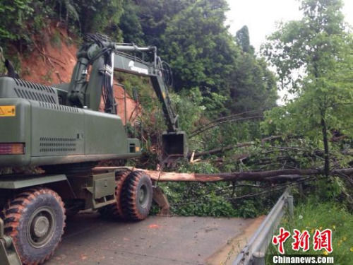 5月8日，官兵正在使用挖掘機(jī)清除道路障礙。　賴橋泉 攝