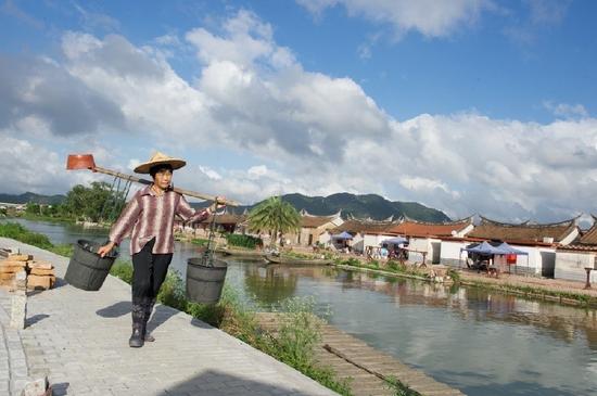 5月27日，埭美村一位村民挑桶經過村前小河