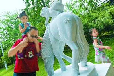 排隊購買“猴年馬月”特色郵品后，人們喜歡摸一摸“馬上封侯”的雕塑，為家人祚福。