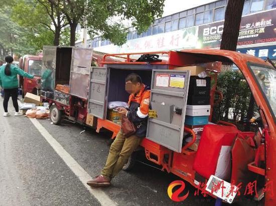 11月21日，蘆淞市場，一位快遞員在等待客戶接收包裹(圖文無關)(記者謝慧攝)