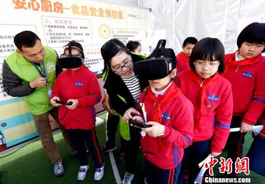 活動現場，小學生通過VR(虛擬現實)技術設備模擬廚房場景，在互動中學習生熟分開，菜品搭配與油鹽使用的廚房食品安全知識。　記者劉可耕 攝