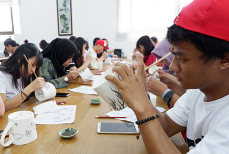 印度尼西亞學生正在繪制青花瓷茶杯圖案。(華僑大學華文學院供圖：楊惠晶 張芬妮)