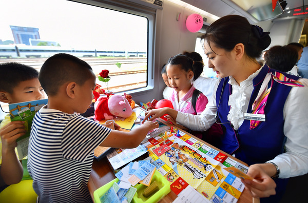 北京鐵路局天津客運段值乘的廈門北至北京南G324次列車乘務(wù)員與兒童旅客互動做游戲。