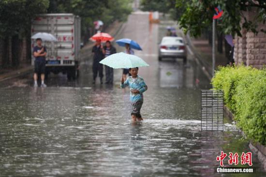 6月12日，市民在積水的道路中出行。當日，貴陽市氣象臺于6時28分將暴雨黃色預警信號升級為暴雨紅色預警信號，持續降雨造成貴陽市多處路段嚴重積水。<a target='_blank' href='http://www.chinanews.com/'>中新社</a>記者 賀俊怡 攝