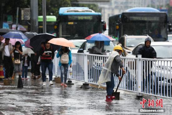 資料圖：行人在雨中出行。 黃芷昕 攝