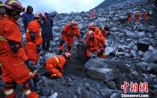  救援人員在挖掘遇難者遺體。　劉忠俊 攝