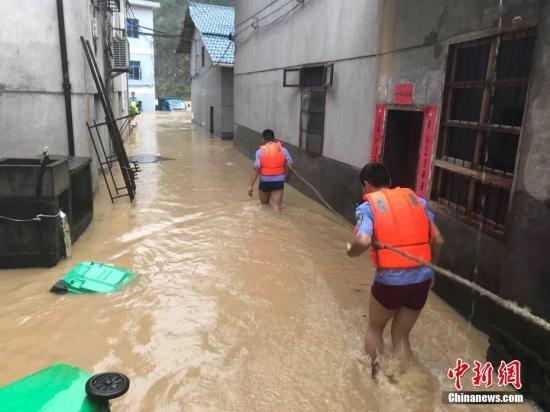 圖為浙江省麗水市遂昌縣民警在積水中準(zhǔn)備營(yíng)救居民。