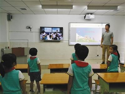 學生們通過遠程在線教育系統與海口市濱海第九小學的學生一起上音樂課。