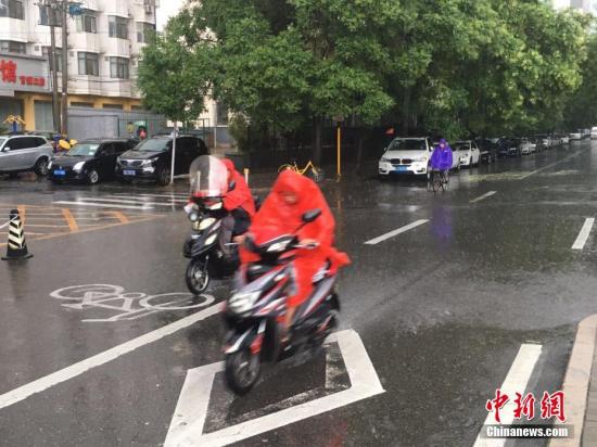 6月23日清晨，北京降雨持續，并出現了短時大雨。據北京市氣象局官方微博消息，北京市氣象臺今日6時發布：今天白天小到中雨并伴有雷電，傍晚局地伴有短時大風或冰雹，北轉東風2、3級，最高氣溫24℃；夜間有雷陣雨，東轉北風2、3級，最低氣溫19℃。圖為北京阜成路，市民雨中騎行。 <a target='_blank' href='http://www.chinanews.com/' >中新網</a>記者 富宇 攝