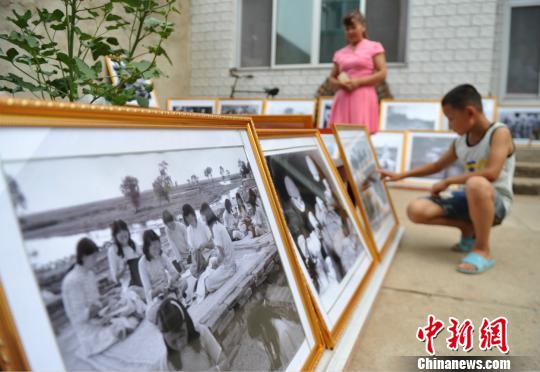圖為群眾在趙文嶺家中參觀馬本齋與回民支隊(duì)事跡圖片展。　苑立偉 攝