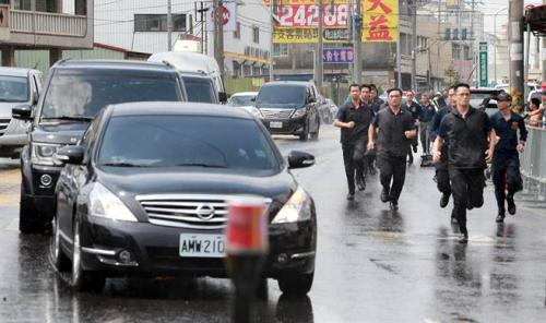 蔡英文6日南下高雄燕巢天后宮參拜，遭到軍公教人士群聚抗議，車隊抵達現場時維安人員跑在車隊旁戒護。(圖片來源：臺灣“中時電子報”)