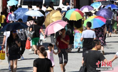 7月12日，廈門一景點游客們紛紛打起傘遮擋烈日。張斌 攝