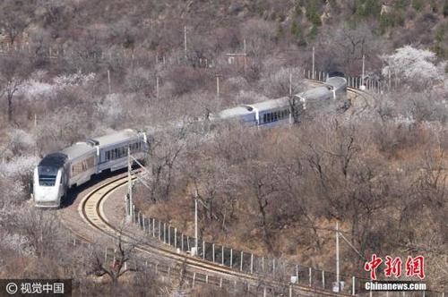 2017年3月26日，北京居庸關長城腳下，山花漸次盛開，和諧號列車行駛在花海中，駛向春天，美如畫卷。王明允 攝 圖片來源：視覺中國