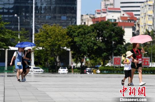 7月13日，廈門市民行走在熱浪滾滾的路面上。　張斌 攝