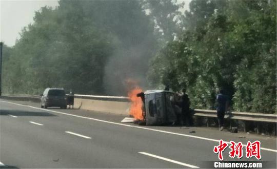 圖為：杭甬高速寧波段一輛面包車側(cè)翻后起火，好心人救一家7口。　何蔣勇 攝