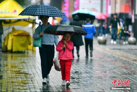 資料圖：9月24日，新疆烏魯木齊市降下秋雨，外出民眾打著雨傘快步前行。 <a target='_blank' href='http://www.chinanews.com/'>中新社</a>記者 劉新 攝