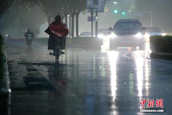 北京市民在雨中前行。 <a target='_blank' href='http://www.chinanews.com/'>中新社</a>記者 劉關關 攝