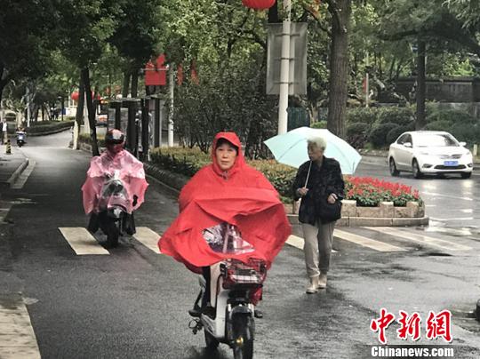 11日，南京迎來降溫降雨。圖為市民披上雨衣出行。　楊顏慈 攝