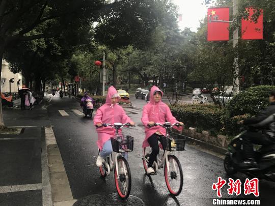 11日，南京迎來降溫降雨。圖為市民披上雨衣出行。　楊顏慈 攝