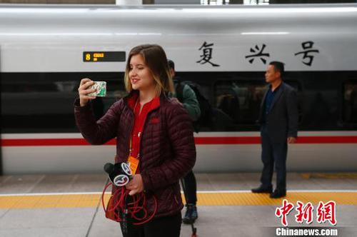 圖為記者在抵達天津后，在車站與高鐵列車“復興號”合影留念。　富田 攝