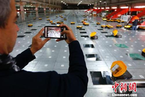 圖為在申通物流公司內，記者在拍攝智能機器人自動分檢系統的工作實況?！「惶?攝