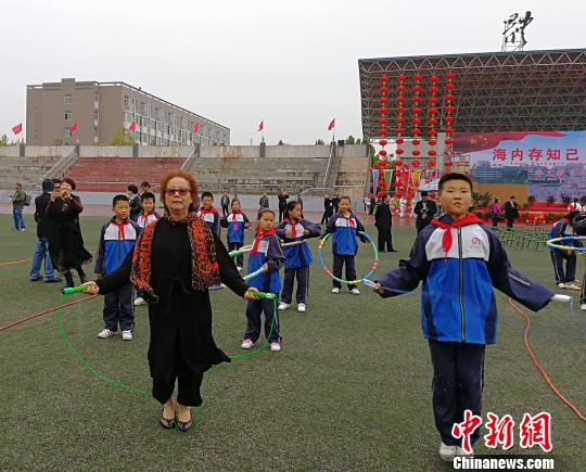 西班牙馬德里愛華中文學校校長黃小捷饒有興致地與學生進行跳繩比賽。　楊杰英 攝