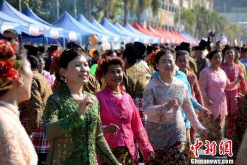 踩街隊伍在美食街上穿行表演，整個活動現場成為歌舞的海洋。　張金川　攝