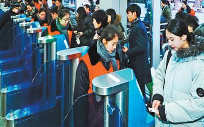2月1日，旅客正在北京西站通過自助驗票設備“刷臉”進站。該站今年增加了18臺人臉識別設備，方便旅客快速進站。本報記者 賀 勇攝