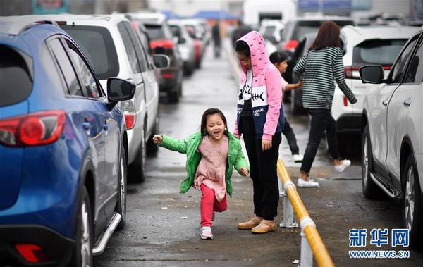 2月23日，小朋友在海口港的車輛等候區玩耍。