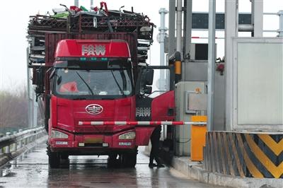 4月13日，京津高速臺湖收費站，一名大貨車司機從車上下來取高速卡。本版攝影/新京報記者 朱駿