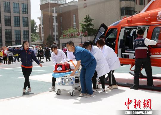 5月23日，遼寧省人民醫院完成中國東北首例異地航空醫療轉運任務。圖為急救人員立即將患者抬上急救床。　朱明宇 攝