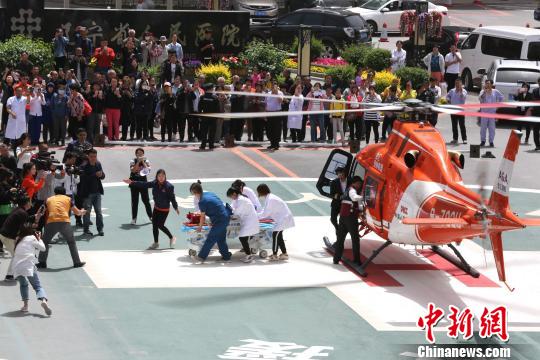 5月23日，遼寧省人民醫院完成中國東北首例異地航空醫療轉運任務。圖為急救人員立即將患者抬上急救床。　朱明宇 攝