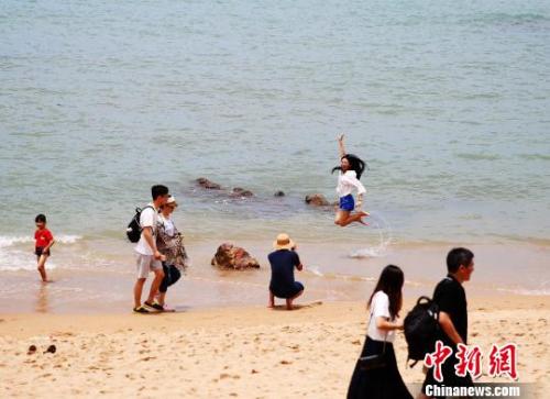 資料圖：端午假期，游客在三亞海邊嬉水。　王曉斌 攝