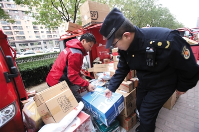 11月8日，城管執法人員協助快遞人員將包裹搬離人行道。