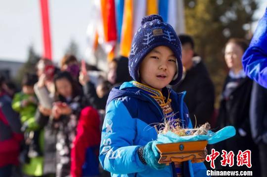 圖為小孩拿著貢品準備祭火。　胡杰 攝