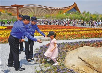 城管勸離進入花壇拍照的游客。北京市城管執法局供圖