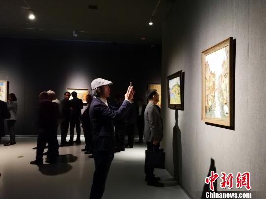 圖為，在“印象山東——俄羅斯油畫家寫生作品展”上，觀眾在喜歡的作品前駐足觀賞、拍照?！O宏瑗 攝