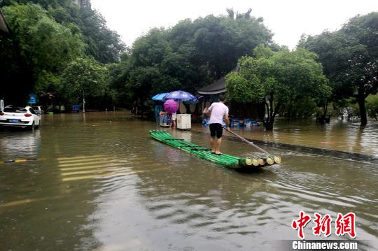 圖為桂林穿山公園部分被淹，附近民眾用竹箋出行?！√茐魬?攝