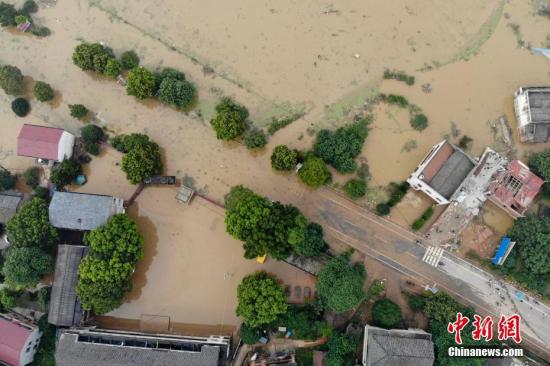 7月11日，湖南衡東縣多個(gè)鄉(xiāng)村與一些道路仍然浸泡在洪水中。連日來(lái)，衡東縣出現(xiàn)了持續(xù)強(qiáng)降雨天氣，造成該縣17個(gè)鄉(xiāng)鎮(zhèn)、233個(gè)村、22個(gè)社區(qū)普遍受災(zāi)。衡東縣防汛抗旱指揮部啟動(dòng)防汛Ⅰ級(jí)響應(yīng)急響應(yīng)。10日，衡東縣霞流鎮(zhèn)洣河村洣水河堤發(fā)生兩處漫堤決口，決口寬度分別約為50米和30米，霞流鎮(zhèn)第一時(shí)間組織附近村民轉(zhuǎn)移。圖為衡山縣通往衡東縣的東健大道被洪水阻斷。楊華峰 攝