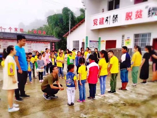 西南交通大學“砥力筑夢”暑期社會實踐隊隊員與貧困地區小朋友們玩“蘿卜蹲”游戲。