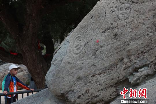 在寧夏賀蘭山巖畫景區內，這在觀看巖畫的游客。　于晶 攝