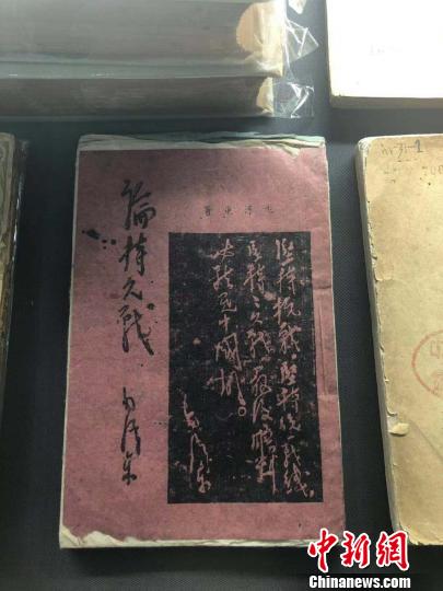 一本用白、紅、藍(lán)等五種顏色紙張印刷而成的《論持久戰(zhàn)》。　李庭耀 攝
